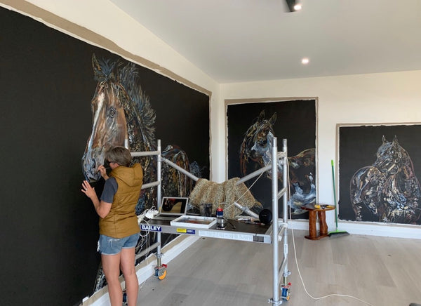 Working from the scaffold, four paintings running at once